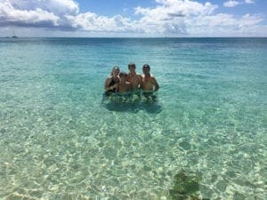Grand Cayman Vacation Kids, Family with older children in blue water of Cayman Islands Mile Beach -Grand Cayman Vacation with kids