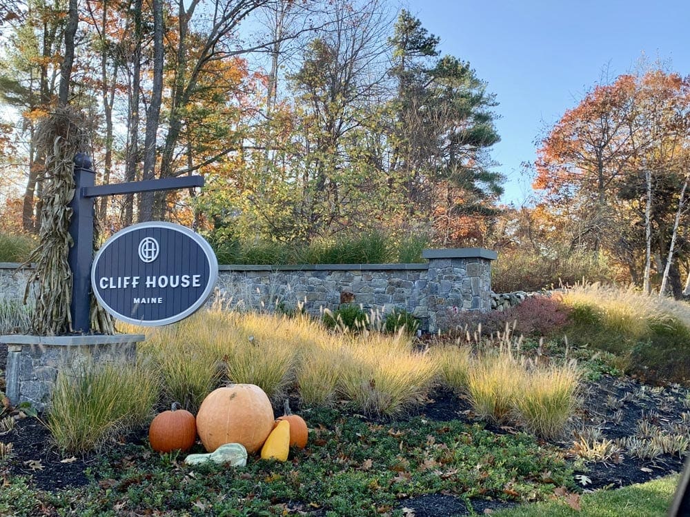 The sign of the hotels outside the Cliff House hotels with colorful pumpkins under it