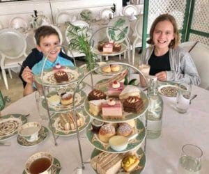 Two kids enjoy a lavish afternoon tea at Kensington Palace in London.