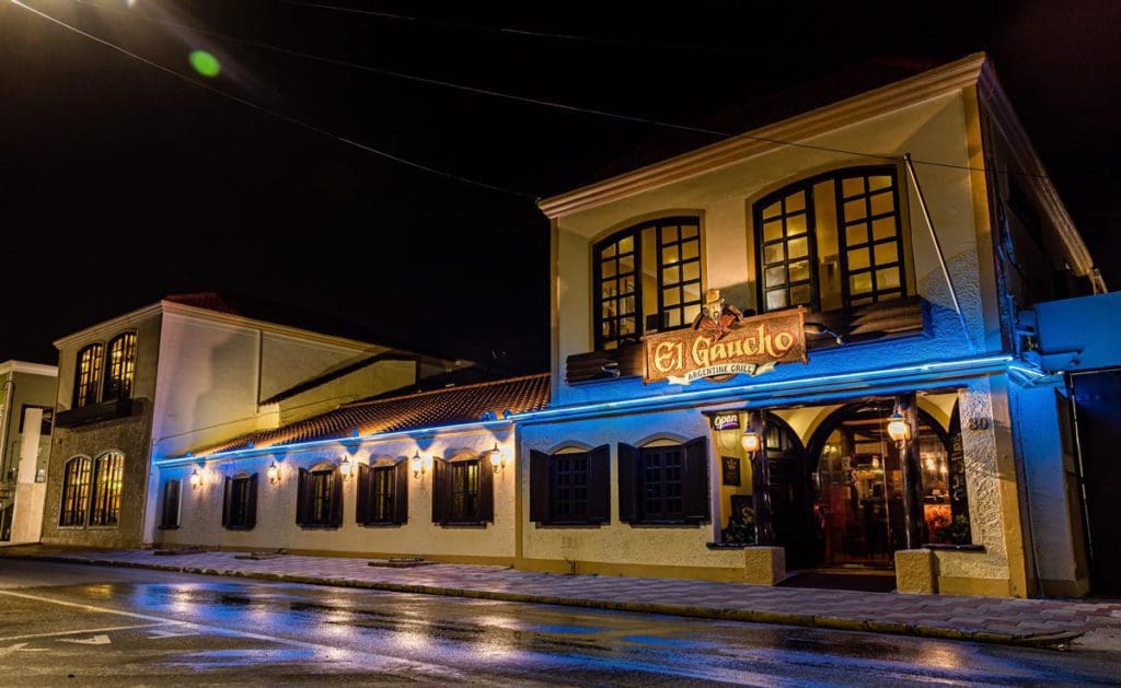 The lit-up exterior of El Guacho Argentine Grill at night.