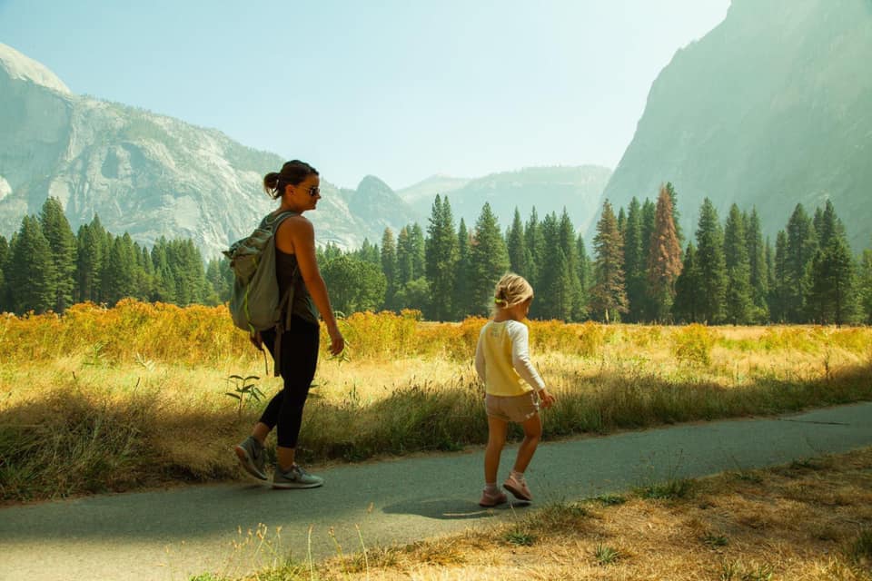 Women and girl on a walk along a paved path at Yosemite.