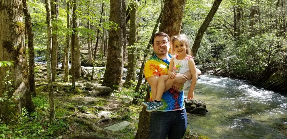 Father and daughter posing for picture in forest at the Great Smoky Mountains National Park.