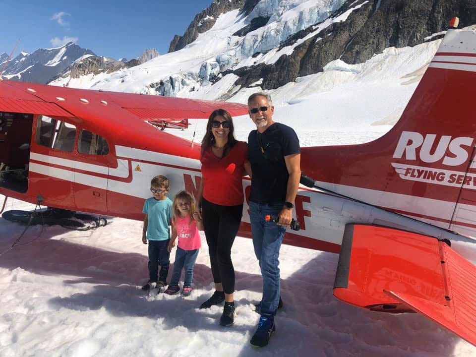 Family in front on a plane in Denali, one of the best national parks for families.