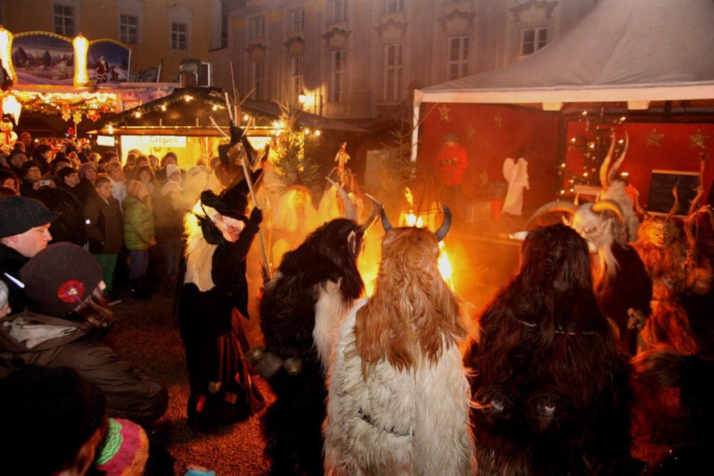 Several people stand around a bonfire at the Passau Christmas Market.