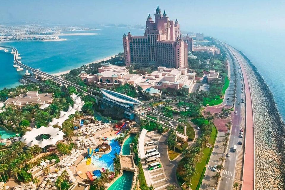 An aerial view of the impressive grounds at the Atlantis, The Palm, featuring pools, palms, and beach access.
