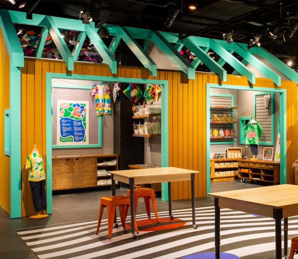 Inside, CAMP, A Family Experience Store, featuring bright colors and kid-sized seating.