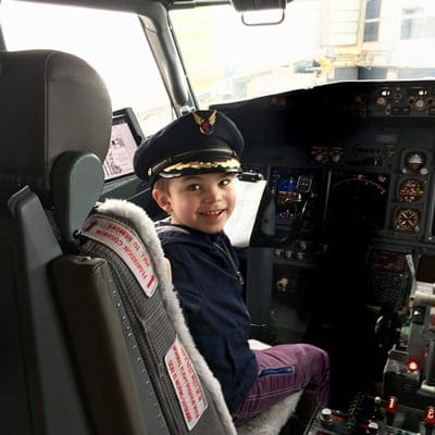 Boy dressed as pilot in cockpit of U.S. airline