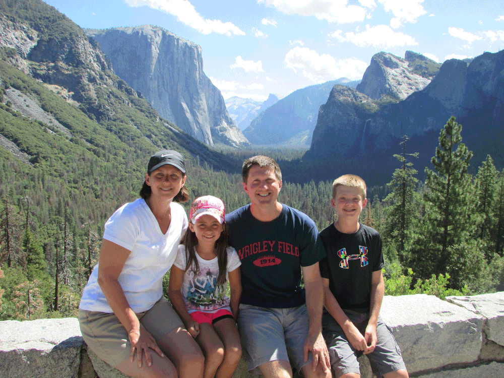Family posing on stone wall at Yosemite National Park