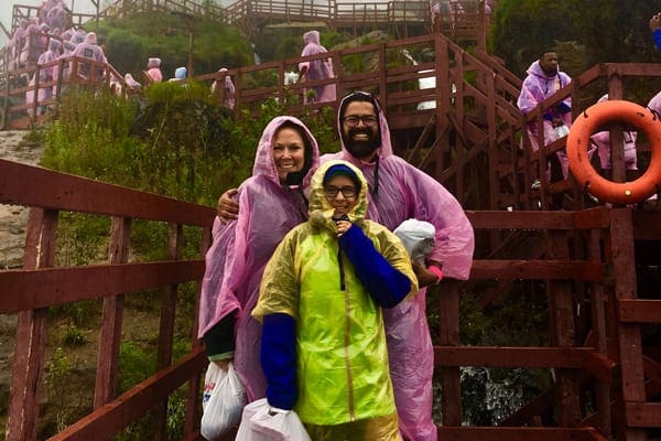 Niagara Vacation Families, Family on the stairs in front of Niagara Falls wearing rain coats
