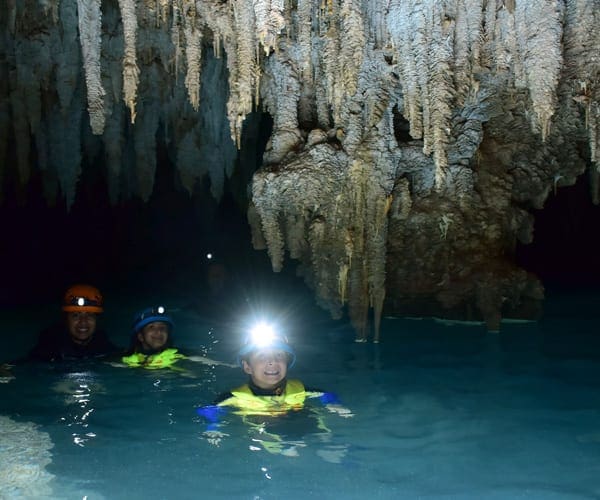 kids in the caves swimming with flashlights in Rio Secreto