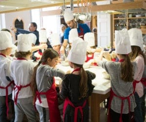 Cooking class in Rome with young children in white chef hats