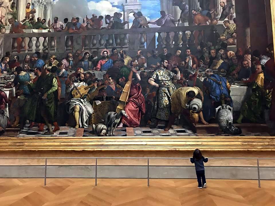 Young child stairs at a huge Parisian masterpiece.