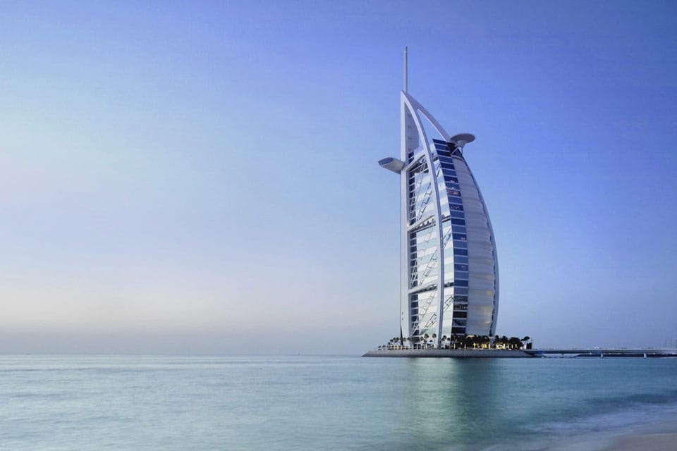 The Burj Al Arab extends from a private island like a ship's sail on a clear day.