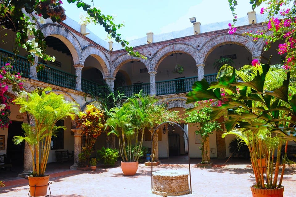 The central coutyard within Convento de La Popa, featuring bright pink flowers.