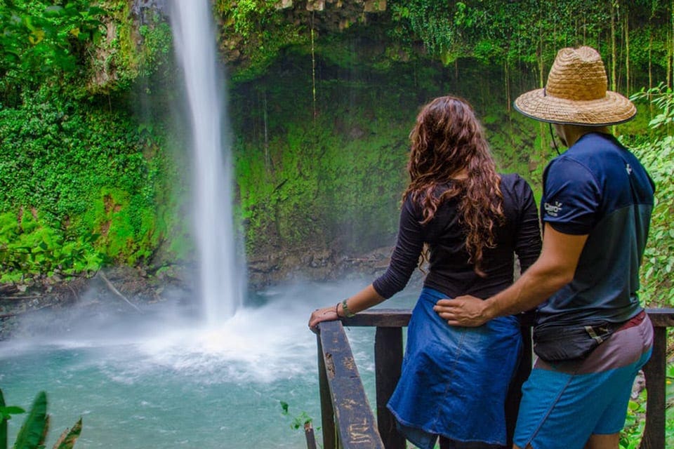 A couple overlooking the La Fortuna Waterfall in Costa Rica.