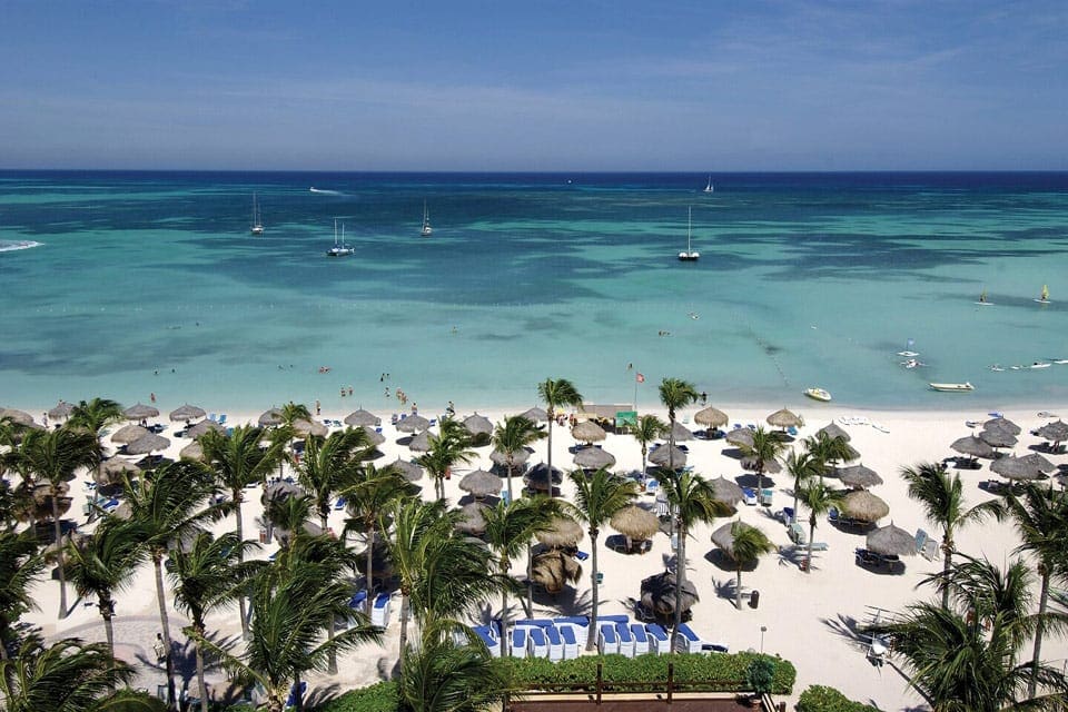 Aerial view of the Marriott’s Aruba Surf Club, one of the best family resorts in Aruba, featuring cabanas and an expansive beach.