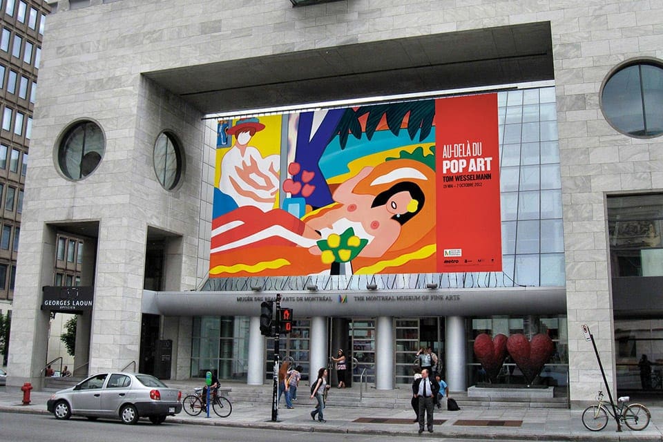 The entrance to the Montreal Museum of Fine Arts, featuring a large, colorful exibit banner.