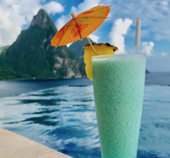A large green cocktail sits on the beach in Saint Lucia.