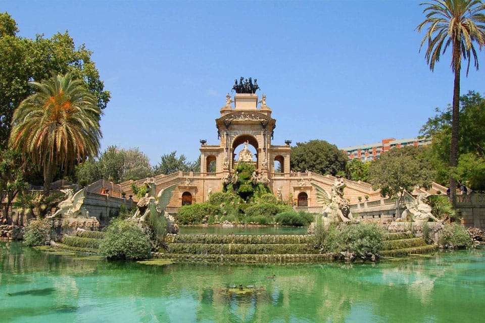 One of the stunning fountains within Parc de la Ciutadella, featuring turquoise waters and lush flowers.