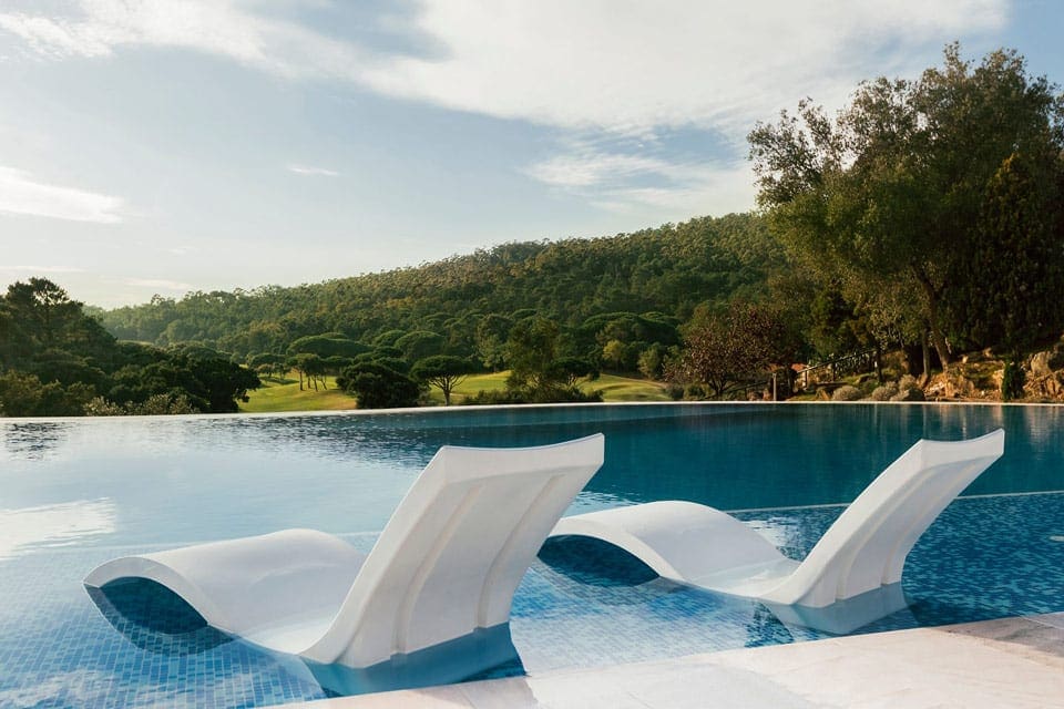 Two loungers sit in the pool overlooking a scenic view at Penha Longa Resort.