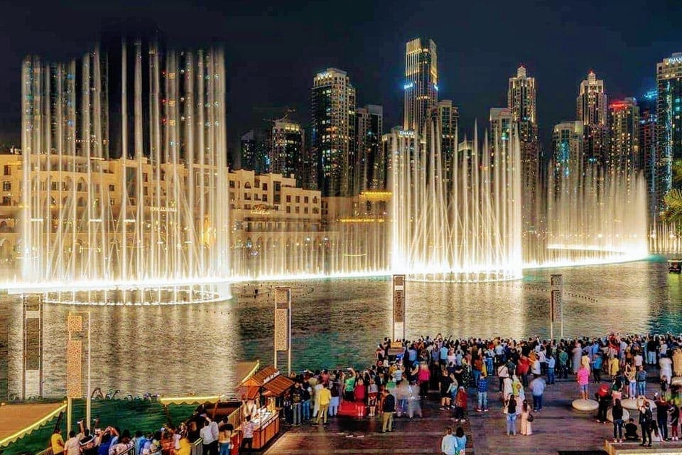 The Burj Khalifa Fountain Show at night, with a crowd of people enjoying the show, one of the best things to do in Dubai with kids.