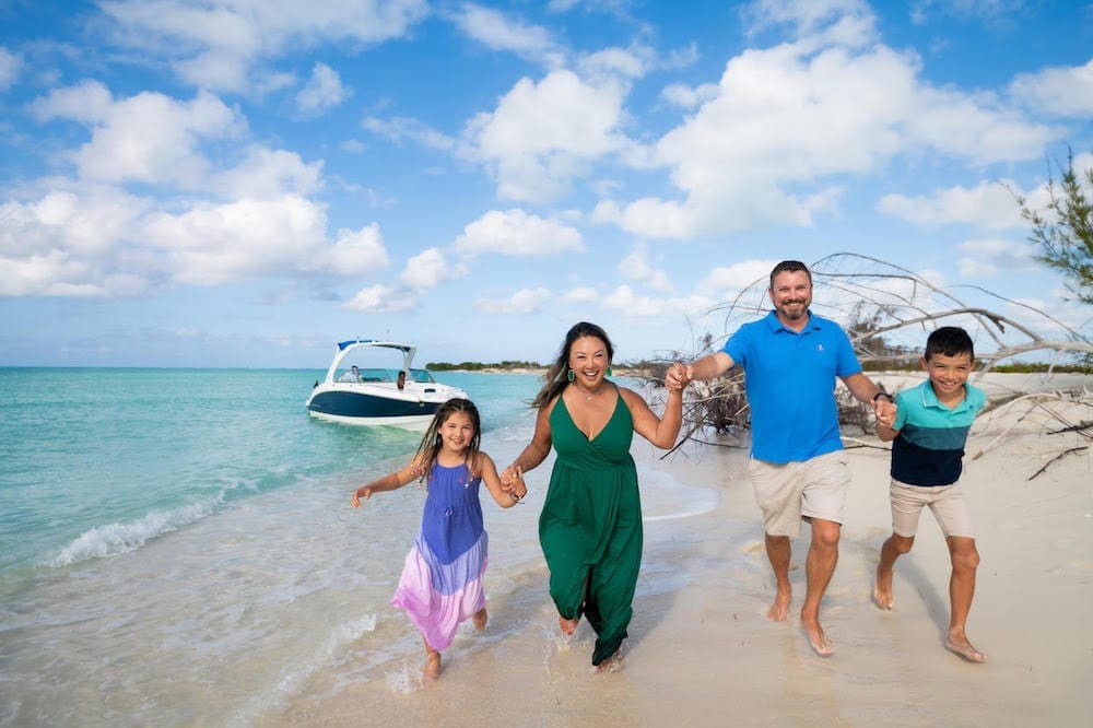 A family of four runs along a beach in Turks and Caicos.