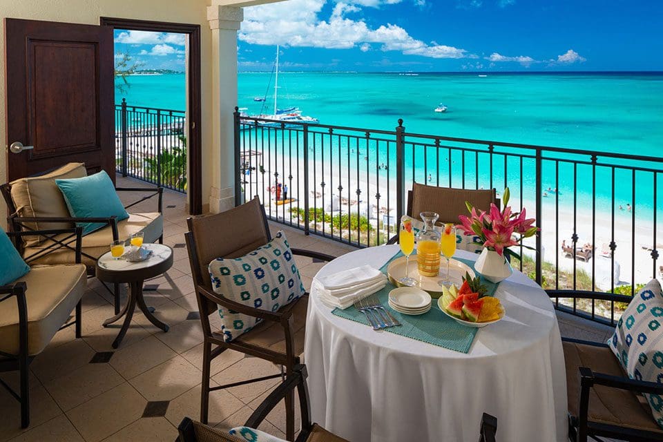 On a balcony over looking the ocean, a table is set for breakfast at Photo Courtesy:  Beaches® Turks & Caicos Resort.