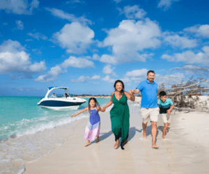 Vivian family running on the beach in Turks and Caicos holding hands while taking family photoshoot