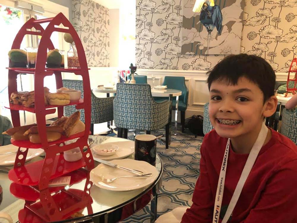 A young boy enjoys afternoon tea at the Ampersand Science Team Room in London.