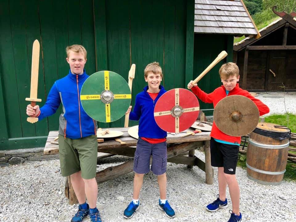 Three kids with craft shield and swords. Creating together on your virtual vacation to Norway is a great way to make memories!