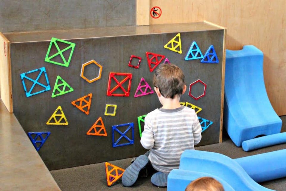A young boy plays at an interactive exhibit area with magnetics at Children’s Creativity Museum, one of the best things to do in San Francisco with kids.
