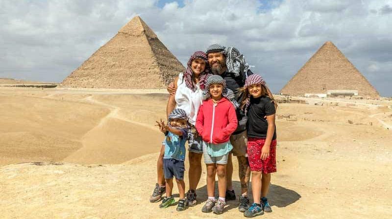 Family of five in front of pyramid in Egypt.