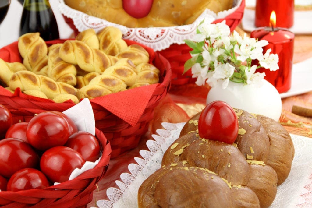 A Greek table is filled with red colored eggs and traditional Easter food. Red eggs are an important park of the Greek tradition.