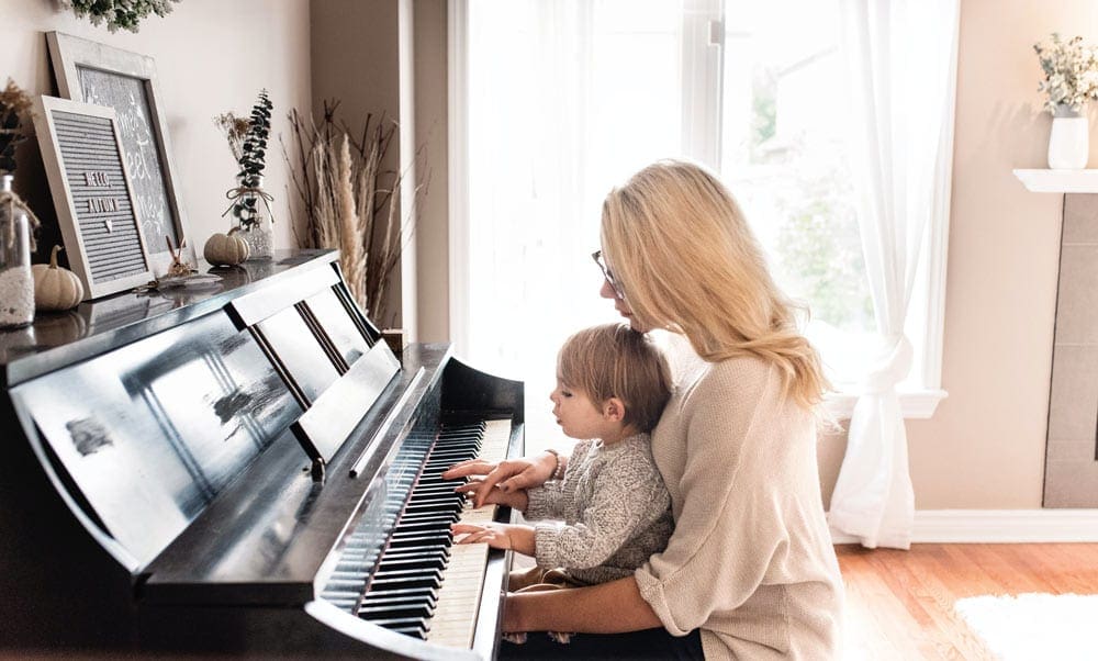 Mother and a child playing a piano together. Music is an important component of our virtual vacation to Naples and Pompeii.