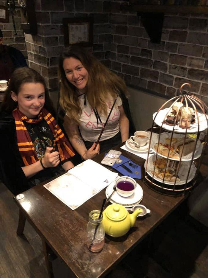 A mom and her daughter, dressed in Harry Potter-inspired clothing, enjoy high tea at the Potion Room in London.