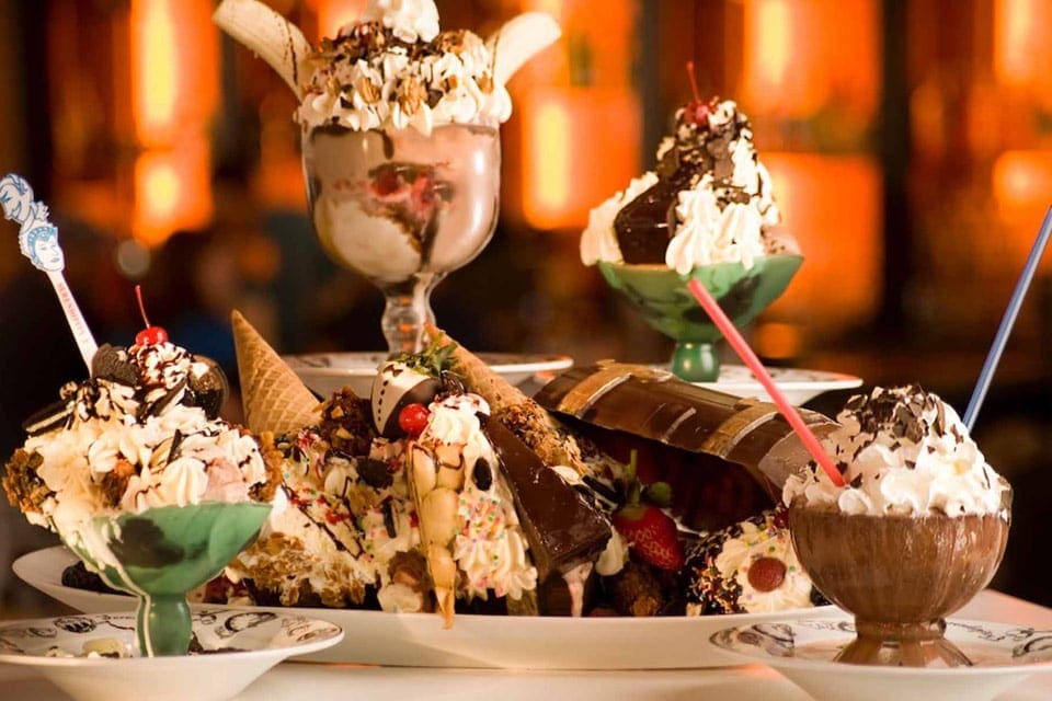 A table is laden with desserts like malts and ice cream dishes at Serendipity 3.