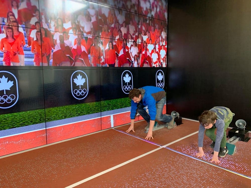 A father and son take position at the starting line of a running track inside the Canadian Olympic Experience in Montreal.