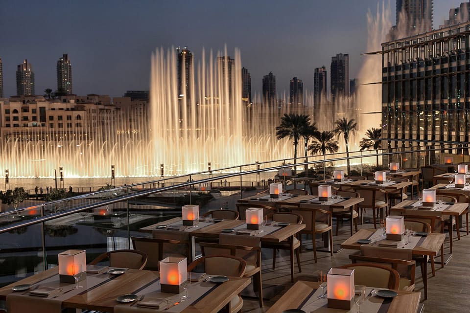 Outside view of the Armani hotel in Dubai with fountains in the background.