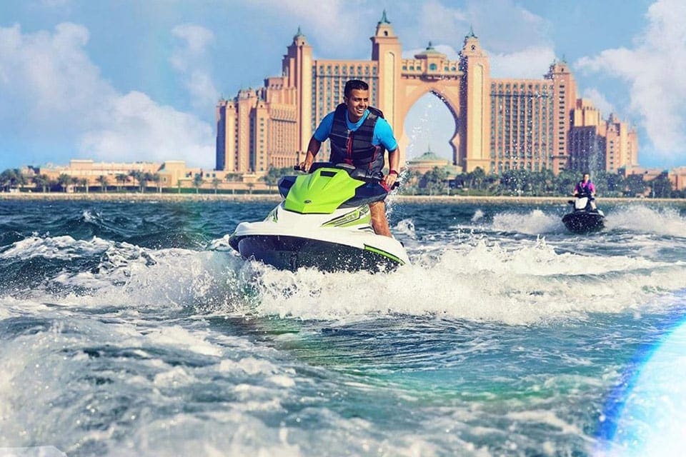 A man and woman jet ski together while staying at the Atlantis, The Palm.
