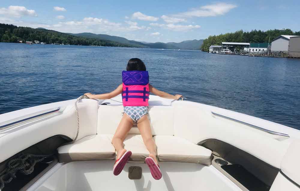 Little girl on boat looking at water at Lake George
