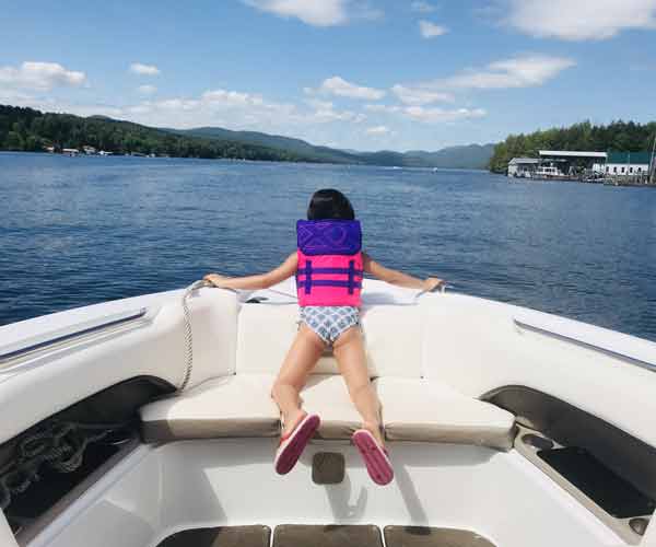Little girl on boat looking at water at Lake George