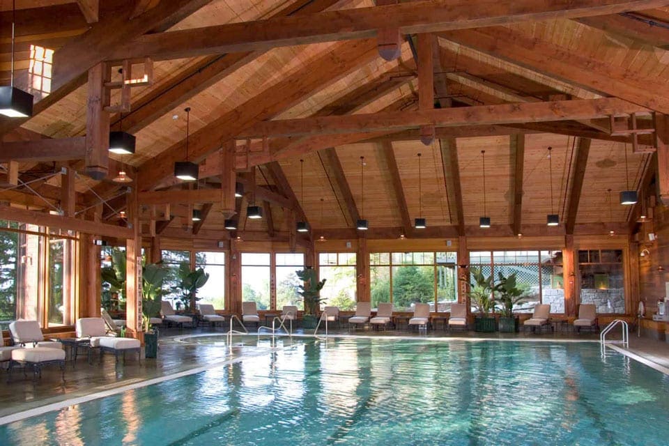 Indoor pool with white lounge chair and high vaulted ceiling at Mohonk Mountain House.