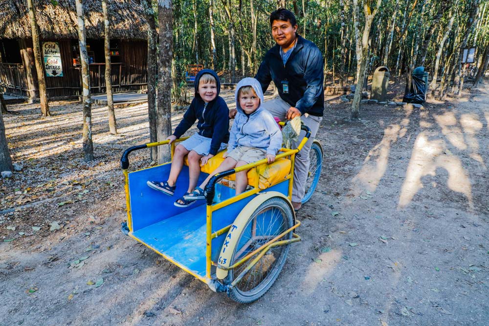 Two kids in bike taxi in Nohoch Mul Playa del Carmen, driven by a local man.