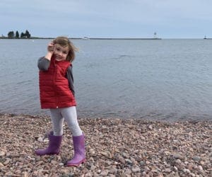 Little girl on a pebble beach of Lake Superior