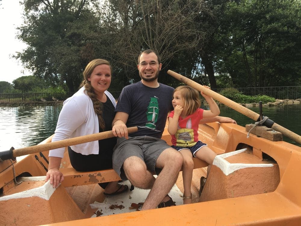 Family of three in a paddleboat at Villa Borghese in Rome, Italy.