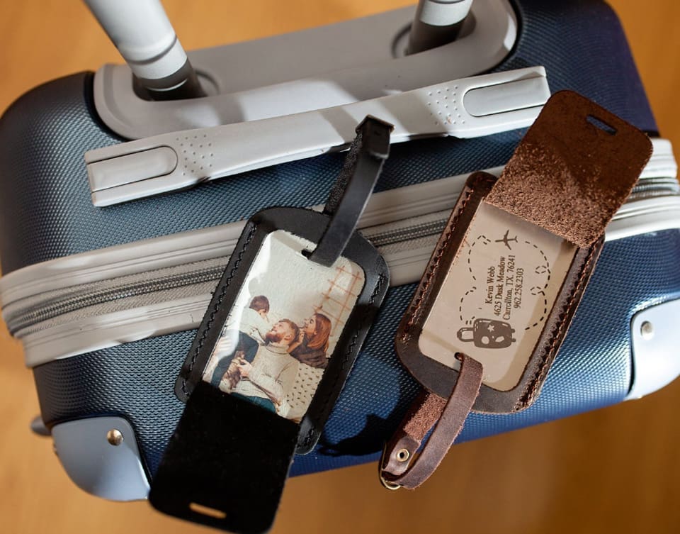 Two personalized luggage tags on a carry-on size suitcase, one of the best travel gifts for Mothers Day.