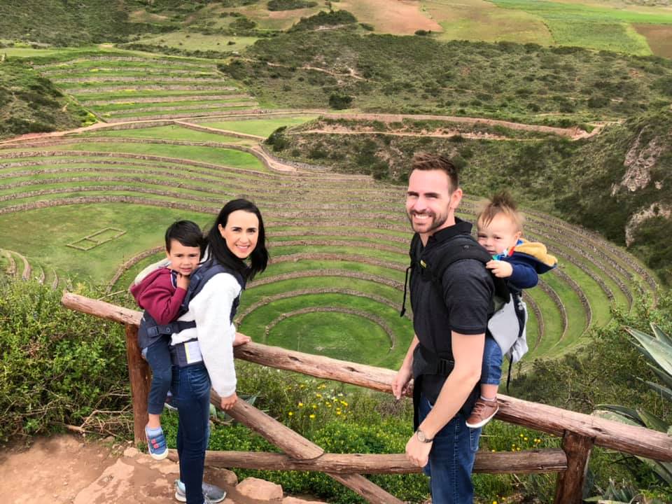 Family of four stands above a ruin in Moray, a great day trip on our Peru family vacation itinerary.