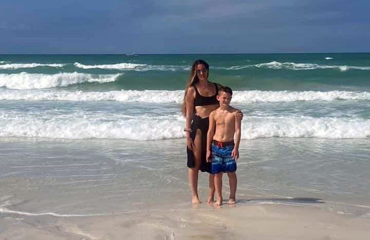 Mother and son posing in front of ocean in Siesta Key, one of the best Florida beaches for families.