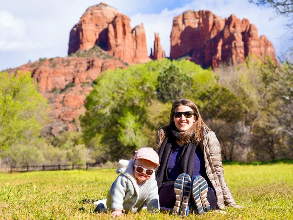 Mother and infant sit in front of a desert landscape in Sedona, one of the best places for families in the U.S.
