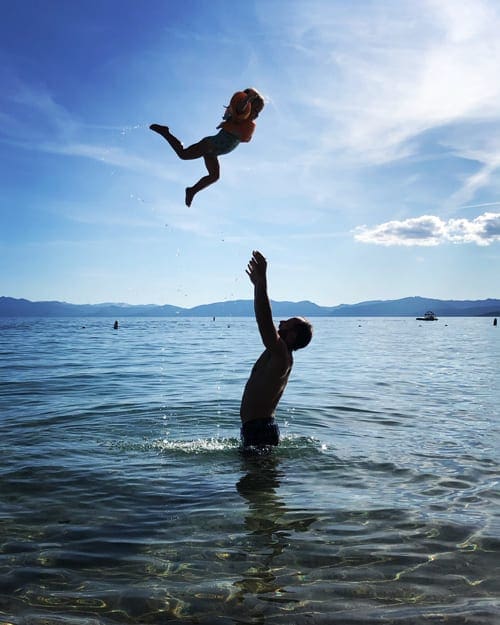Father throwing the baby girl in the air in Lake-Tahoe